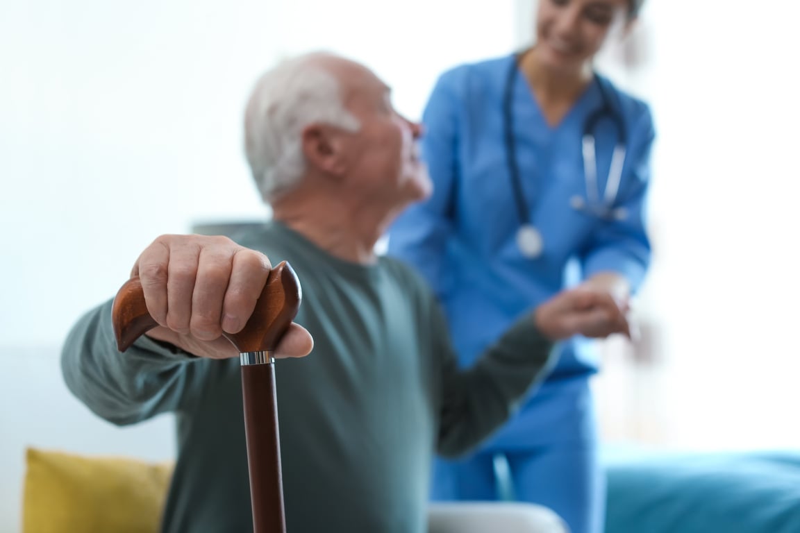 Care Worker Helping Elderly Man in Geriatric Hospice, Focus on H